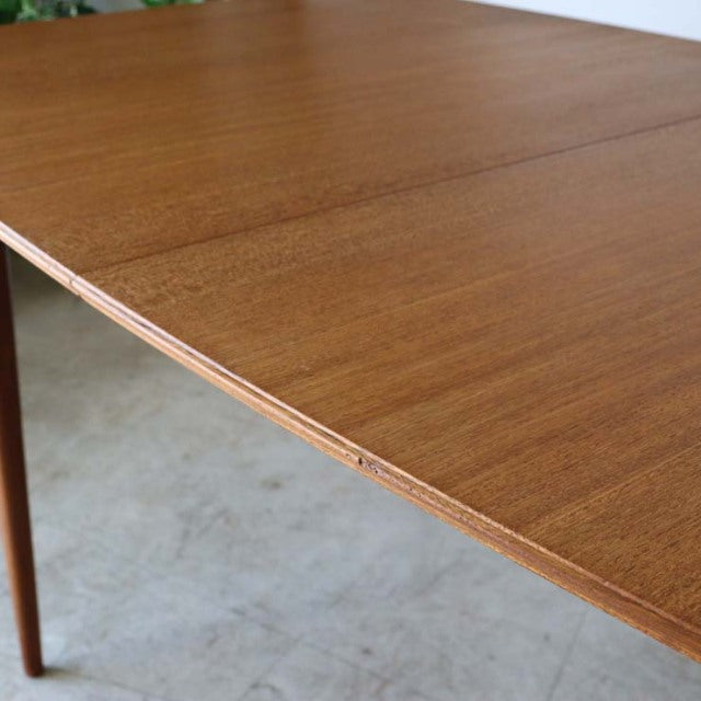 Mid-century British vintage teak dining table by McIntosh with smooth grain and tapered legs.