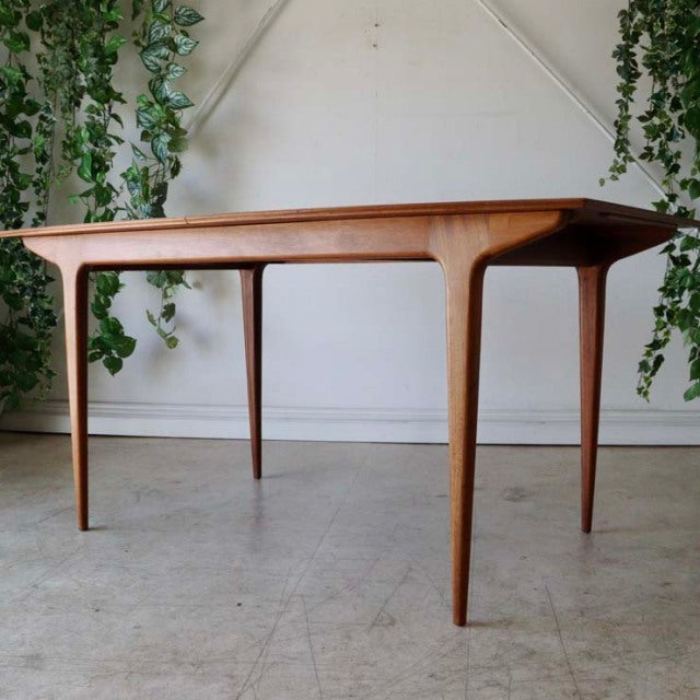 Mid-century British McIntosh dining table in vintage teak with tapered legs and visible wood grain.