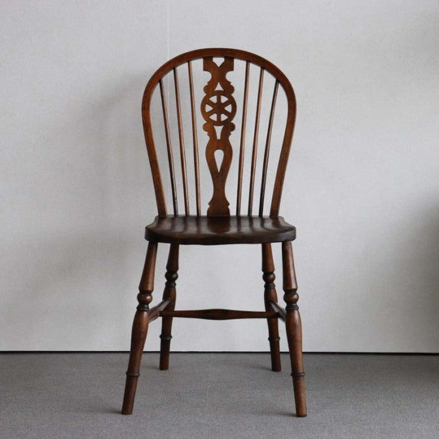 Vintage British mid-century teak kitchen chair with curved spindle back and decorative carved center slat, turned legs, and.