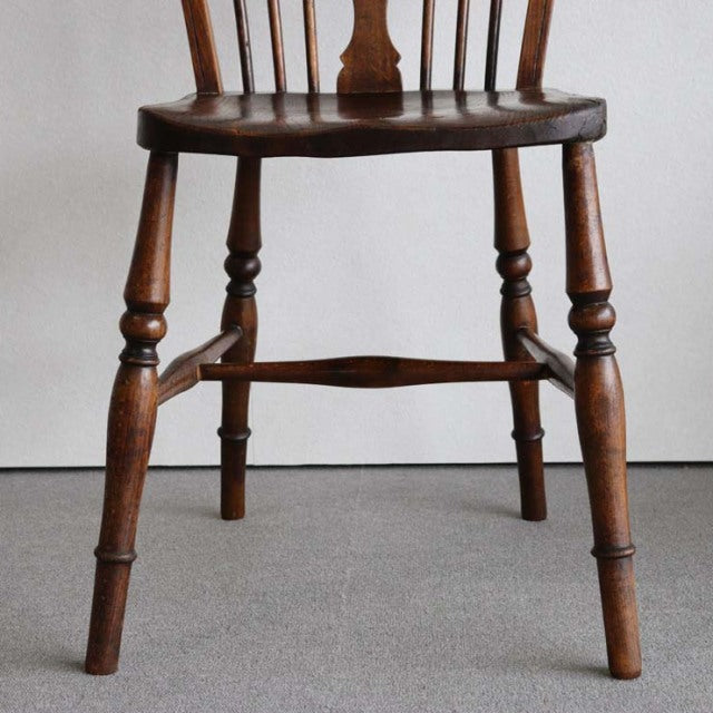 Vintage British mid-century teak kitchen chair with spindle back, turned legs, and stretchers.
