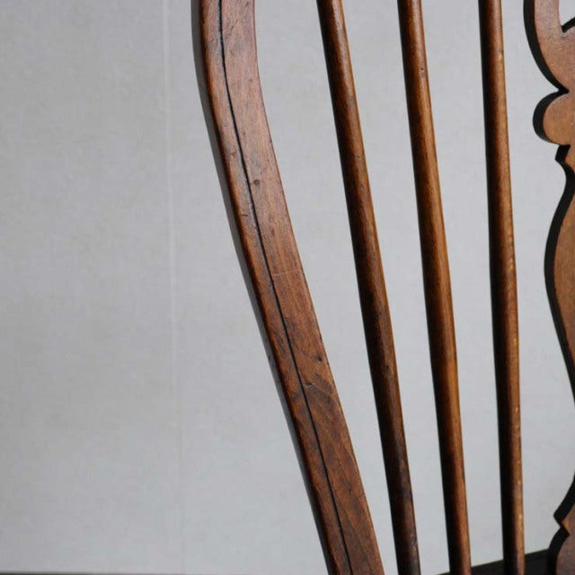 Vintage British mid-century teak kitchen chair with slender vertical spindles and curved wood grain frame.