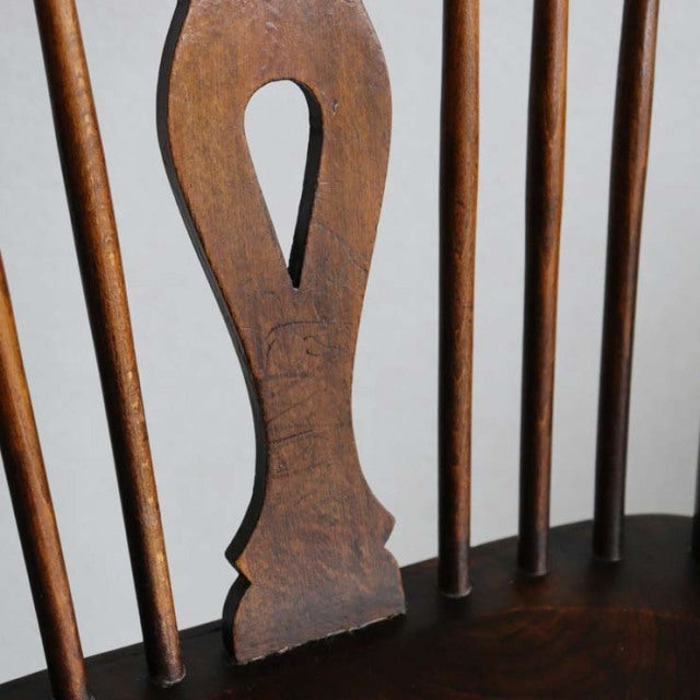 Mid-century British vintage teak kitchen chair backrest with vertical spindle details and warm wood grain.