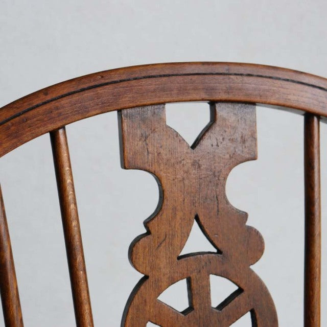 Vintage mid-century British teak kitchen chair backrest with carved geometric details and smooth wood grain.