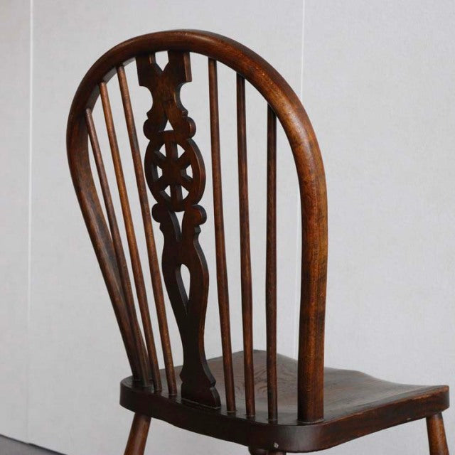 Vintage British teak kitchen chair with mid-century arched backrest and spindle detailing.
