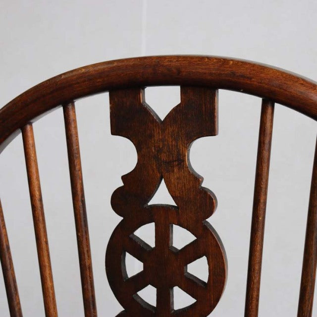 Mid-century British vintage teak kitchen chair backrest with intricate carved crest and slender vertical spindles.