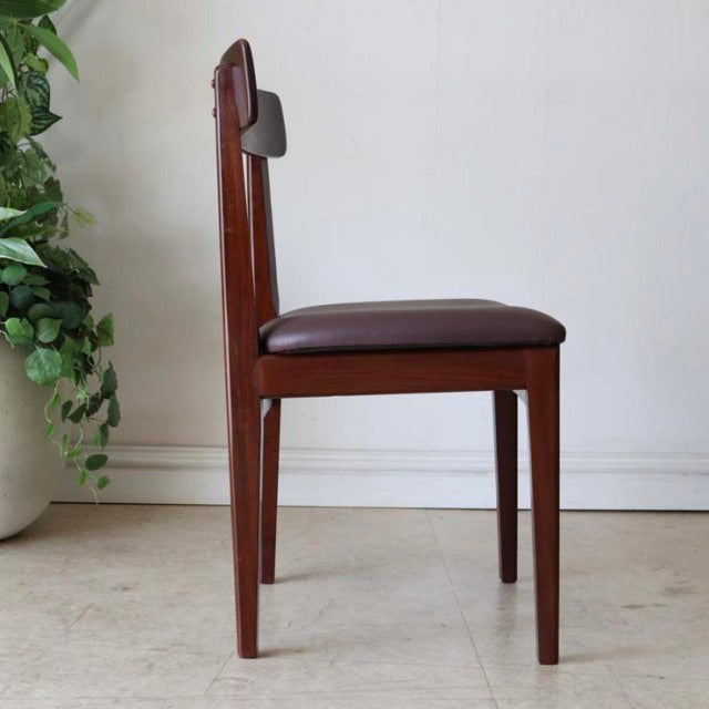 Mid-century British vintage dining chair in teak with rich wood grain, straight legs, and brown leather seat cushion.