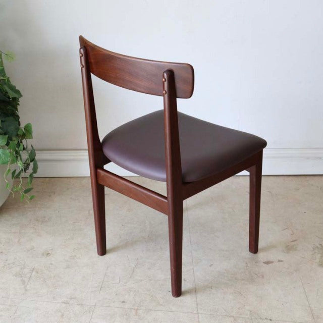 Mid-century British vintage teak dining chair with curved backrest, tapered legs, and dark brown upholstered seat,.