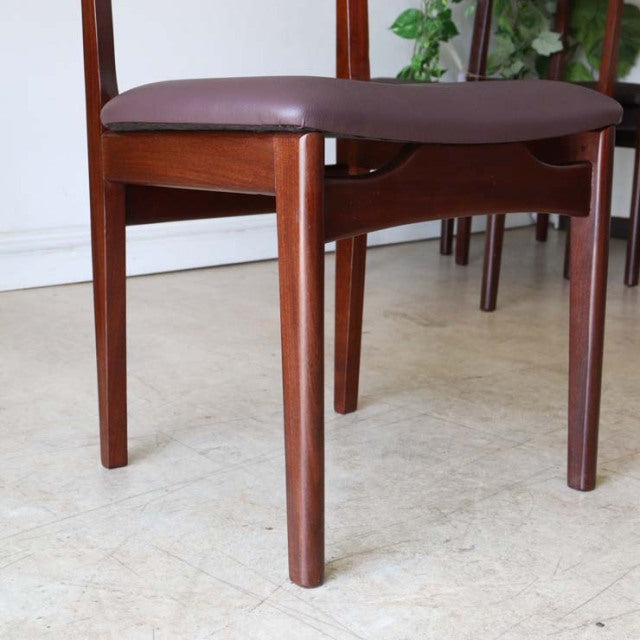 Mid-century British vintage teak dining chair with rich wood grain and brown leather cushion, slender legs and simple.