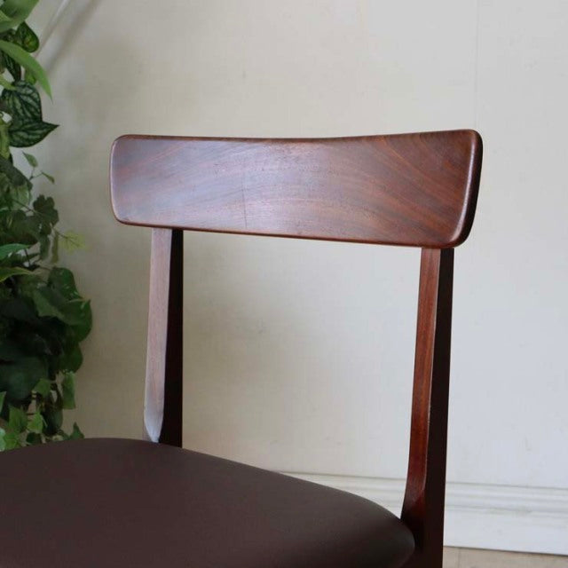 Mid-century British vintage teak dining chair with curved backrest, smooth wood grain, and slender tapered legs.