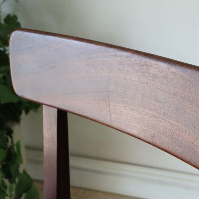 Mid-century British vintage teak dining chair backrest with smooth wood grain and curved design.
