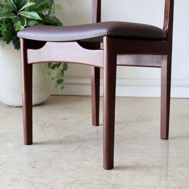 Mid-century British vintage teak dining chair with smooth wood grain, round tapered legs, and dark brown cushioned seat.