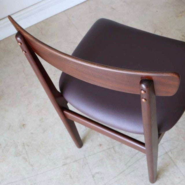 Mid-century British vintage dining chair in teak with curved backrest and dark brown leather seat cushion, showcasing smooth .