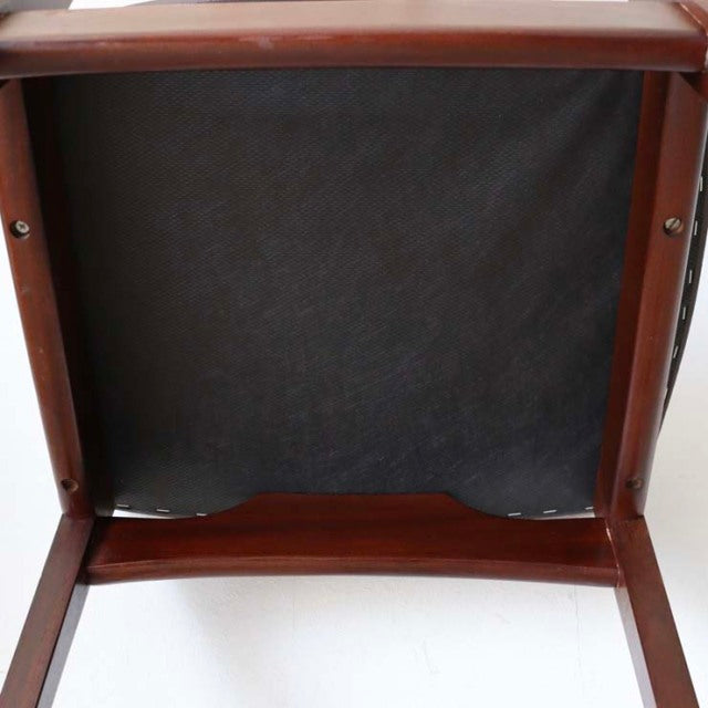 Underside view of vintage British mid-century teak dining chair showing smooth wood grain and sturdy frame construction.