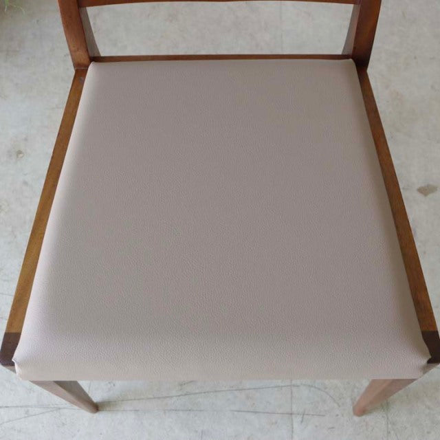 Vintage McIntosh teak dining chair seat with beige cushion, mid-century British design from Denmark, showcasing wood grain.