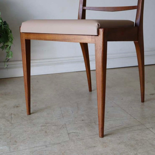 Set of four vintage British mid-century dining chairs in teak with tapered legs and light beige upholstered seats,.