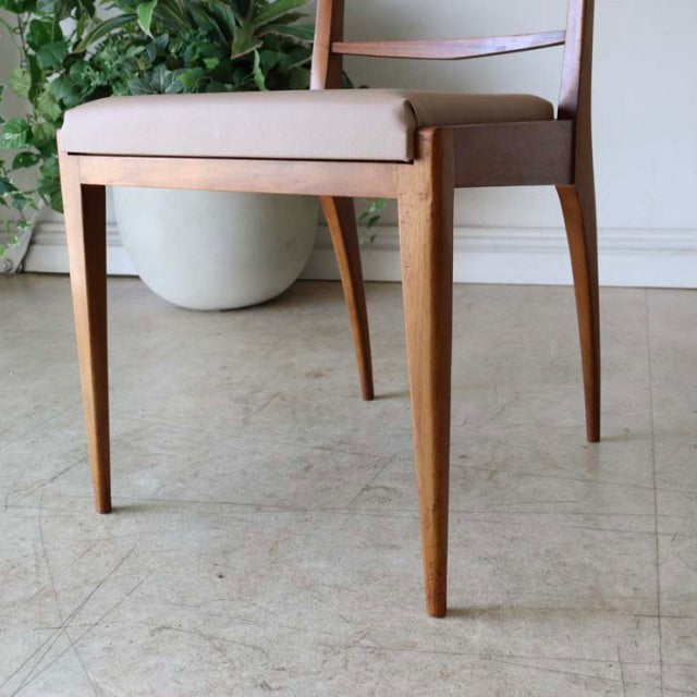 Set of four vintage McIntosh teak dining chairs with mid-century British design, clean lines, and beige upholstered seats.
