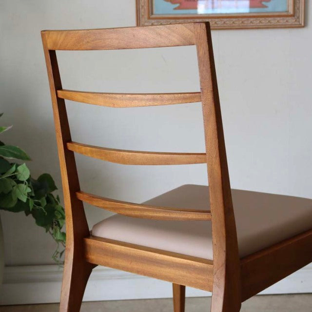 Vintage mid-century British McIntosh dining chair with teak wood frame, curved slatted back, and tan cushioned seat.