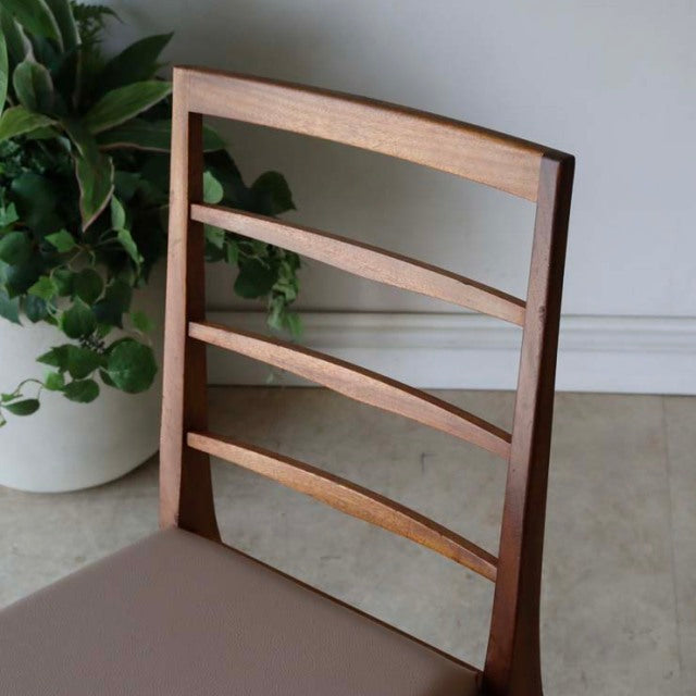 Set of four vintage McIntosh teak dining chairs with mid-century British design, ladder-style backs, and smooth wood grain.