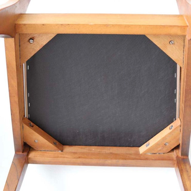 Underside view of vintage teak dining chair seat frame with visible wood grain and corner reinforcements, mid-century.
