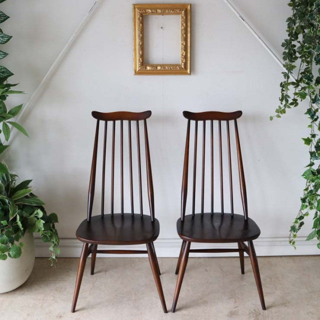 Pair of vintage British mid-century ERCOL Goldsmith highback dining chairs in rich teak with slender spindled backs and.
