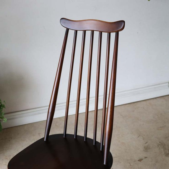 Vintage mid-century British Ercol Goldsmith dining chair in teak with a curved spindle back and gracefully tapered legs.