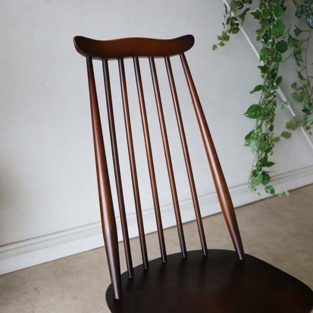 Vintage British mid-century Ercol dining chair in rich teak with slender spindled back and curved top rail.