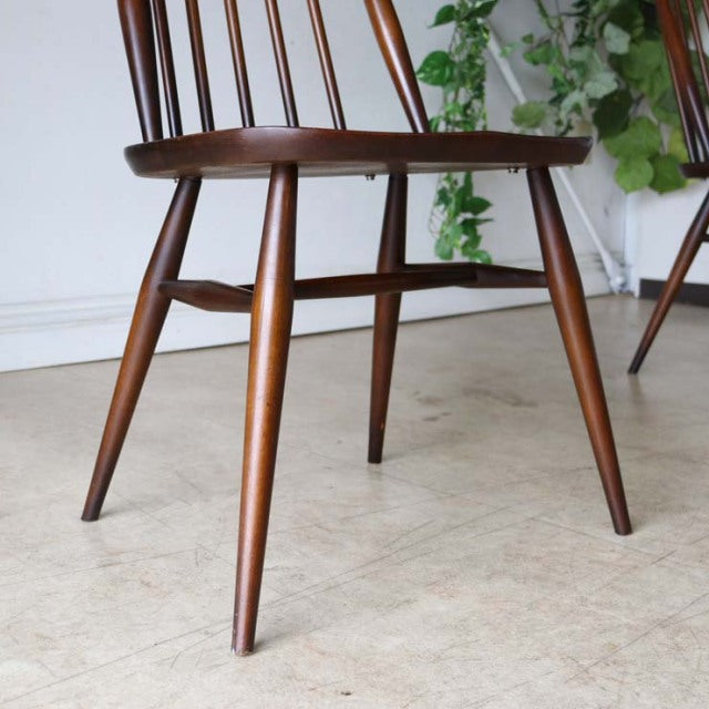 Mid-century British vintage Ercol Goldsmith dining chair in teak with tapered round legs and spindle back.