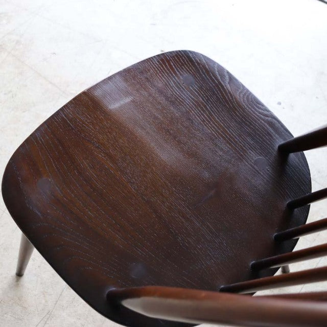 Vintage ERCOL Goldsmith mid-century highback chair in dark teak, showing detailed wood grain and slender spindled backrest.