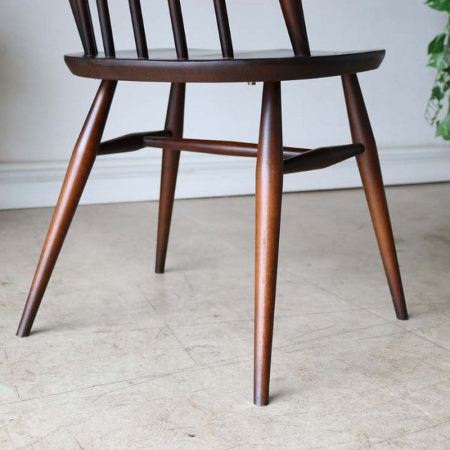Mid-century British ERCOL Goldsmith highback Windsor chair in rich teak with splayed legs and smooth wood grain finish.