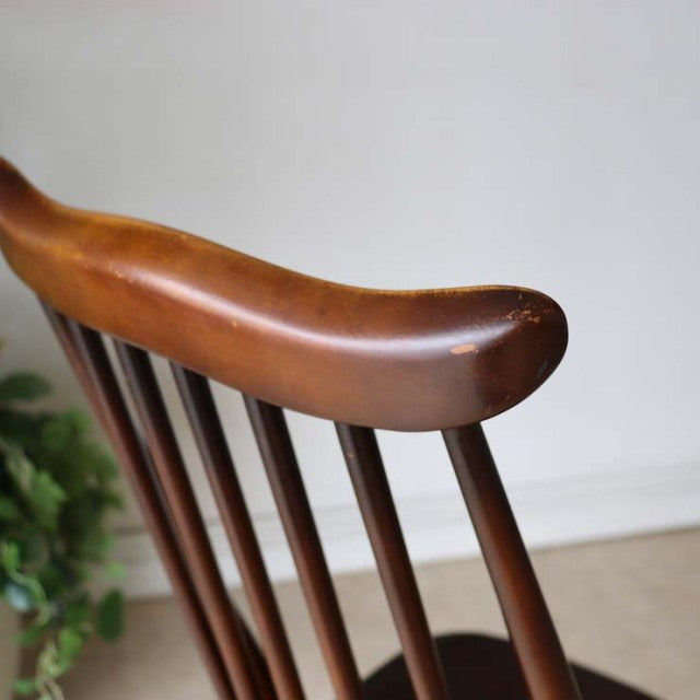 Mid-century British vintage Ercol dining chair with curved teak backrest and slender spindled legs.
