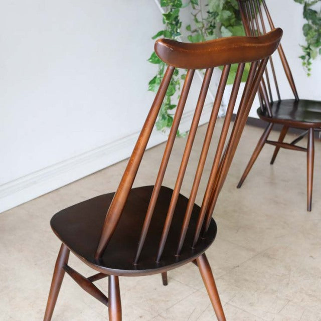 Vintage British Ercol Goldsmith dining chair in teak with slender spindled backrest and black seat, mid-century Danish.