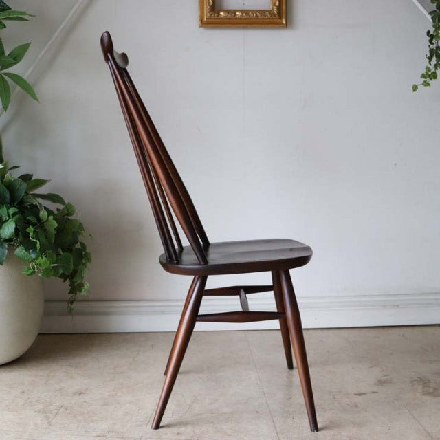 Mid-century British vintage Ercol dining chair in teak with slender tapered legs and spindle backrest.