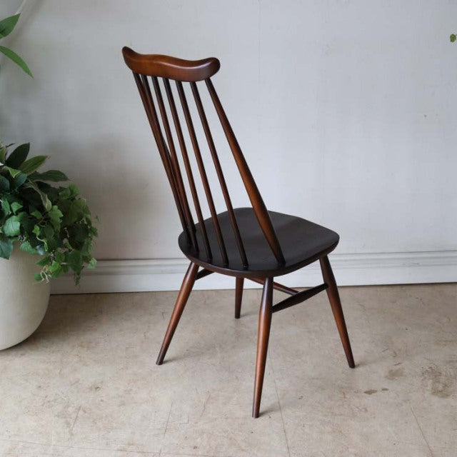 Vintage British mid-century Ercol Goldsmith dining chair in teak with a curved spindle back and tapered legs.