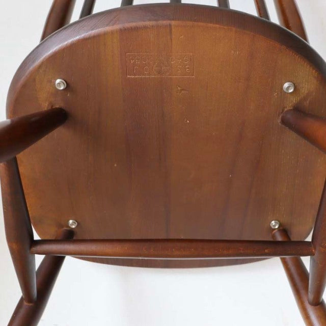 Underside of vintage ERCOL Goldsmith highback Windsor chair in rich teak, showcasing smooth wood grain and sturdy wooden.