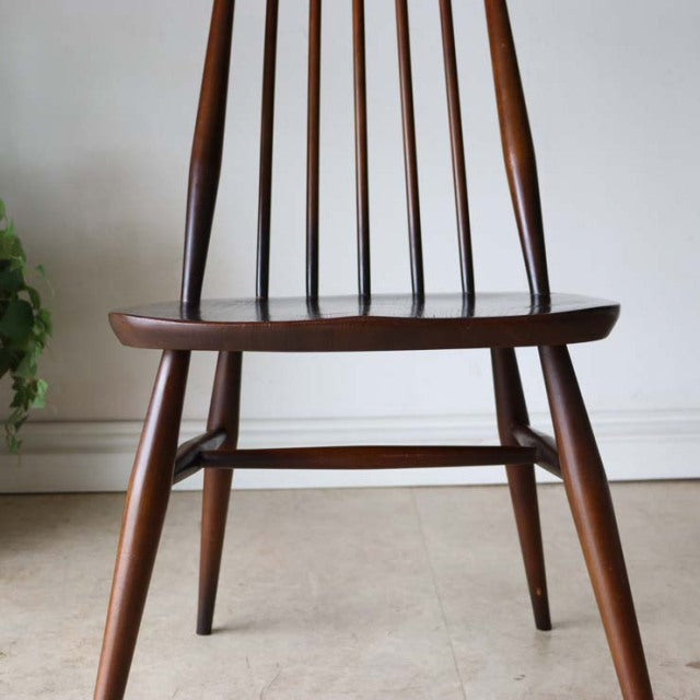 Vintage British mid-century teak dining chair by Ercol with slender spindle back and tapered legs.