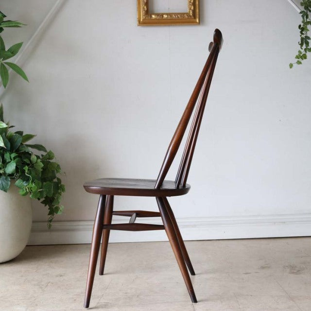 Mid-century British vintage Ercol Goldsmith dining chair in warm teak with slender tapered legs and a tall, curved backrest.