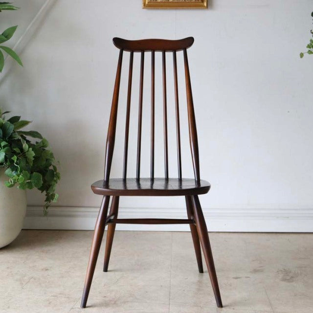 Vintage British mid-century dining chair in teak with slender spindled backrest and tapered legs.