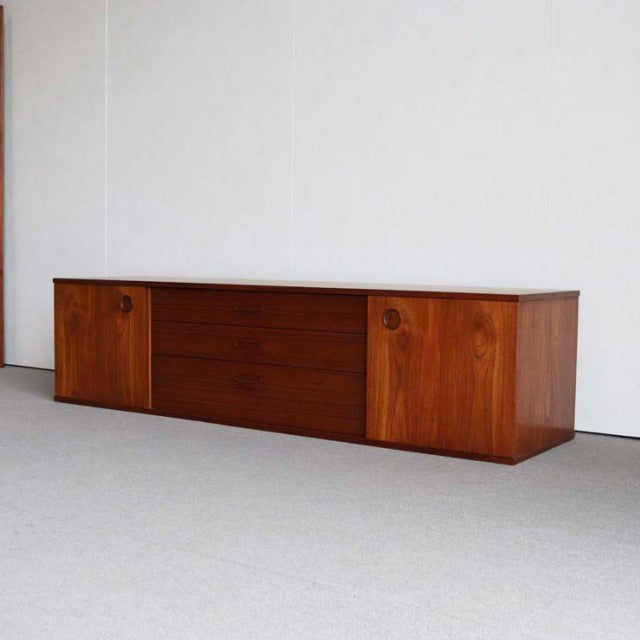 Vintage mid-century AVALON teak sideboard with smooth wood grain, British-Danish design, circular recessed handles, and low.