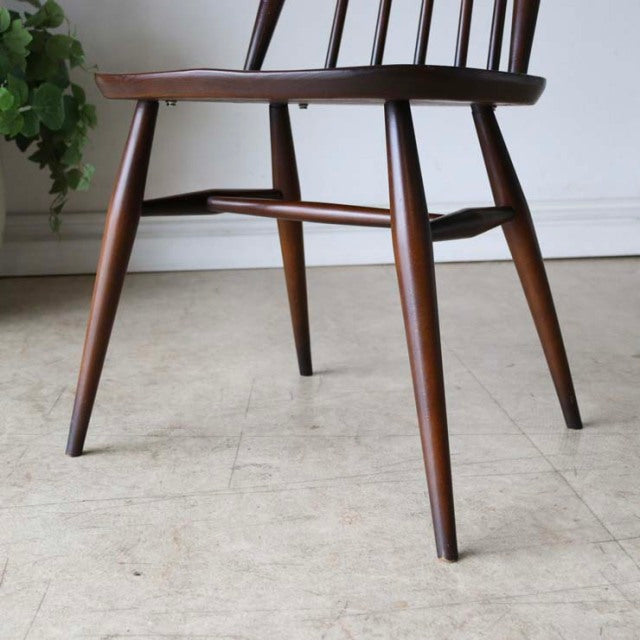 Pair of vintage British ERCOL Goldsmith highback Windsor chairs in rich teak, mid-century design with slender tapered legs.