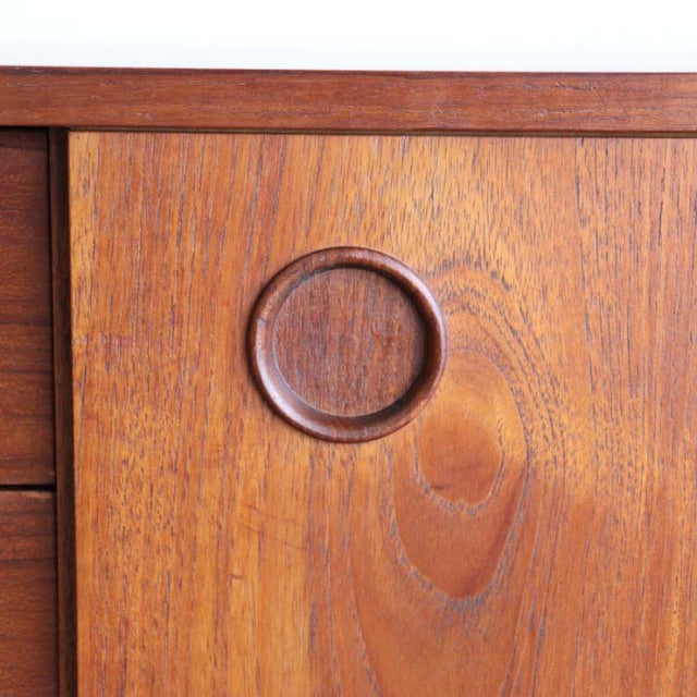 Close-up of vintage teak sideboard door by AVALON showing circular recessed handle and rich wood grain from British.