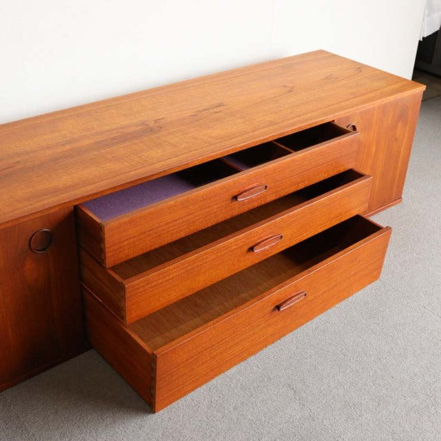 Vintage AVALON teak sideboard with British mid-century design, showcasing rich wood grain and sleek recessed handles, set on .