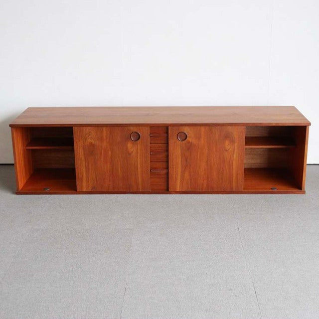 Mid-century British teak sideboard by AVALON with rich wood grain, round recessed handles, and open shelving on both sides.