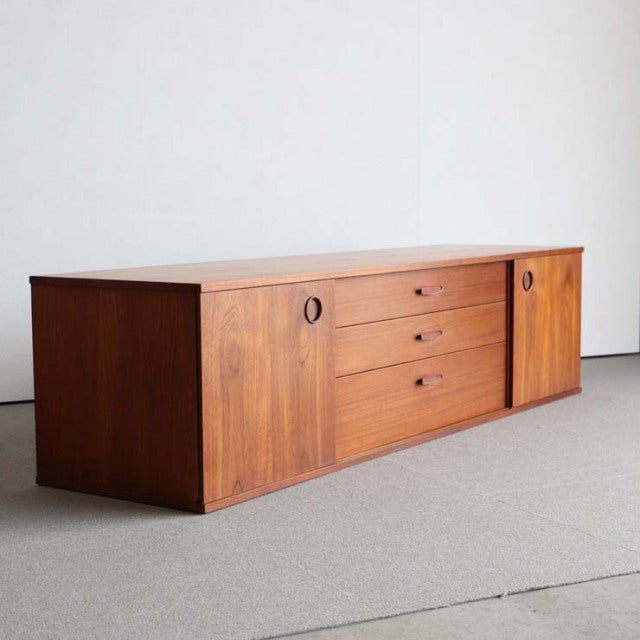 Vintage teak sideboard by AVALON featuring mid-century British and Danish design, round recessed handles, three central.