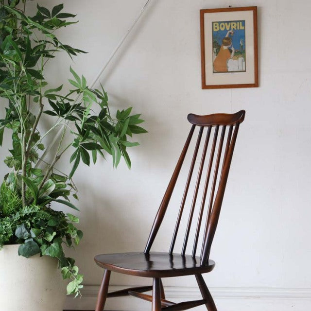 Mid-century British vintage Ercol Goldsmith dining chair in teak with curved spindle backrest and tapered legs.