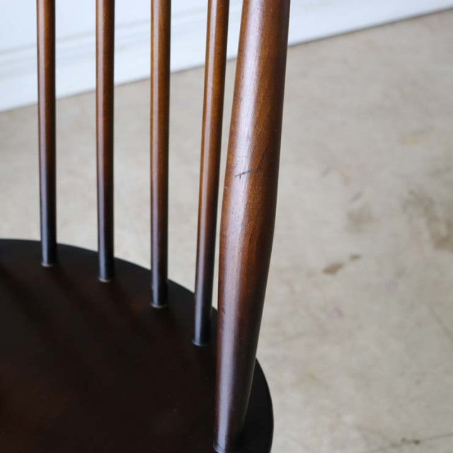 Vintage British mid-century teak dining chair leg and spindles with smooth wood grain and warm brown finish.