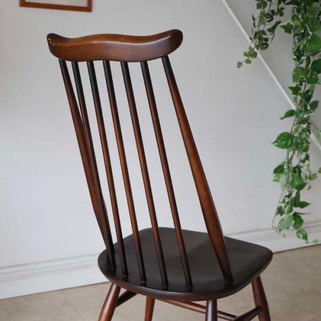 Vintage mid-century British Ercol Goldsmith dining chair in rich teak with curved top rail and slender vertical spindles.