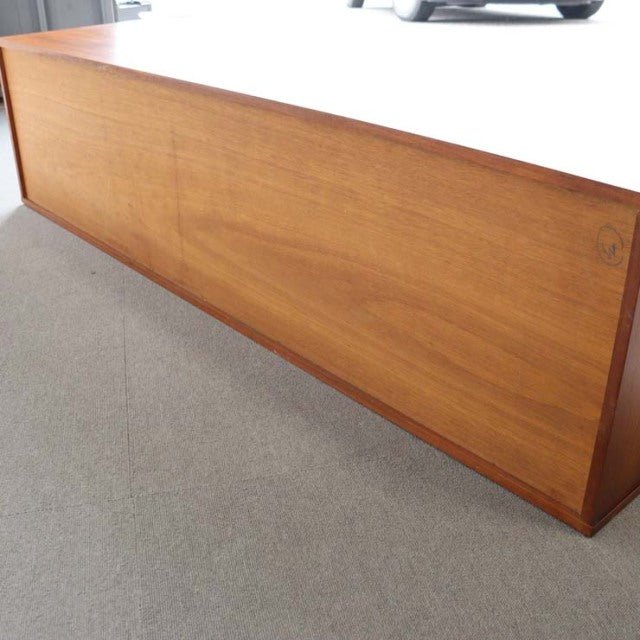 Long vintage teak sideboard by Avalon with smooth wood grain, clean mid-century lines, and flat surface.