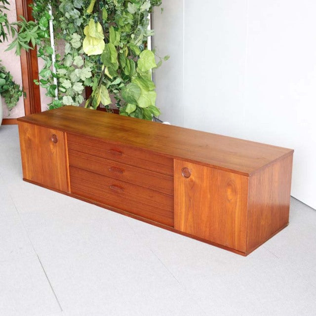 Vintage teak mid-century sideboard by AVALON with British-Denmark design, featuring prominent wood grain, three central.