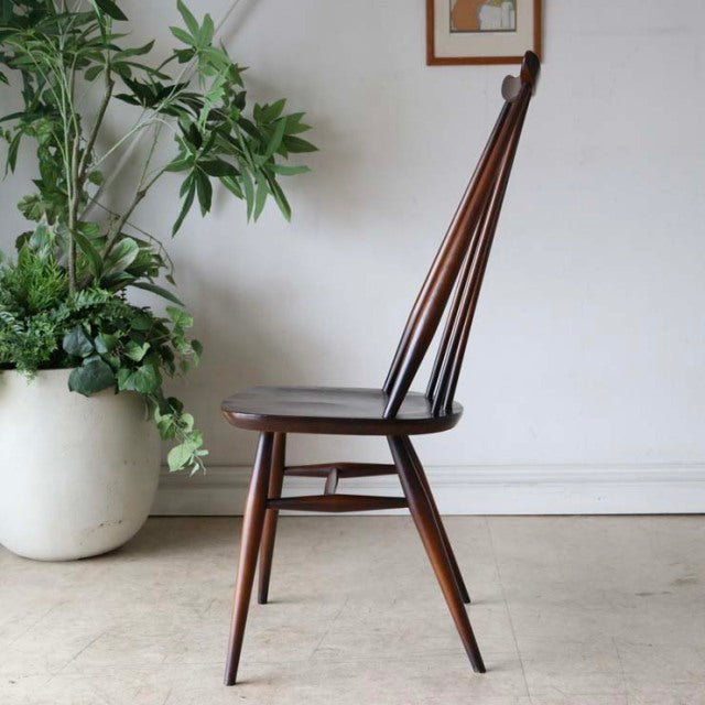Vintage British mid-century dining chair in teak with slender spindled backrest and tapered legs.