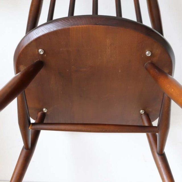 Vintage British Ercol Goldsmith teak mid-century dining chair seat underside showing wood grain and sturdy legs.